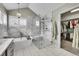 Elegant main bathroom showcasing a modern tub, glass-enclosed shower, and direct access to a walk-in closet at 1011 S Valentia St # 30, Denver, CO 80247