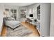 Bright home office with hardwood floors, large windows with shutters, comfortable chaise lounge, and built-in shelving at 1011 S Valentia St # 30, Denver, CO 80247