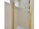 Clean shower with a gold-trimmed glass door, tiled walls, and modern shower head at 1011 S Valentia St # 30, Denver, CO 80247