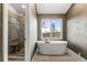 Bathroom showcasing a freestanding tub next to a window and a separate glass-enclosed shower at 5745 S Andes St, Aurora, CO 80015