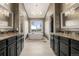 Elegant bathroom featuring dual vanities, a soaking tub under a window, and a chandelier at 5745 S Andes St, Aurora, CO 80015