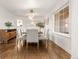 Bright dining room with wood floors, modern light fixture, and view to kitchen at 5745 S Andes St, Aurora, CO 80015