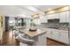Bright kitchen with granite countertops, white cabinets, stainless steel appliances, a breakfast bar, and access to an outdoor seating area at 5745 S Andes St, Aurora, CO 80015