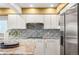 Bright kitchen featuring granite countertops, a tiled backsplash, white cabinets, and stainless steel appliances at 5745 S Andes St, Aurora, CO 80015
