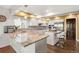 Bright kitchen featuring granite countertops, a tiled backsplash, stainless steel appliances, and a central island with bar seating at 5745 S Andes St, Aurora, CO 80015