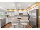 Bright kitchen featuring granite countertops, white cabinets, a tiled backsplash, stainless steel appliances, and a central island with seating at 5745 S Andes St, Aurora, CO 80015