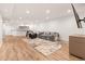 Open-concept living room with ample seating, hardwood floors, and modern bar at 5745 S Andes St, Aurora, CO 80015