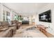 Spacious living room with hardwood floors, large windows, and open layout to kitchen at 5745 S Andes St, Aurora, CO 80015