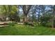 Lush backyard featuring a deck and seating area surrounded by mature trees and colorful flowers at 308 Baron Ave, Lafayette, CO 80026