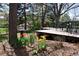 Landscaped backyard with mature trees, a wood deck with outdoor seating, and garden beds at 308 Baron Ave, Lafayette, CO 80026