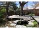 Backyard features a wood deck with outdoor seating, a water feature, and mature trees at 308 Baron Ave, Lafayette, CO 80026