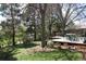 Landscaped backyard features a mature lawn, wood deck with outdoor seating, and a privacy fence at 308 Baron Ave, Lafayette, CO 80026