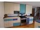 Modern kitchen featuring stainless steel appliances, colorful cabinets, and hardwood floors at 308 Baron Ave, Lafayette, CO 80026