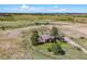 Aerial image of a ranch home with mountain views and rolling fields, corrals, and outbuildings in the countryside at 40121 County Road 21, Elizabeth, CO 80107