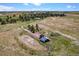 Aerial image of a home, outbuildings, a circular driveway, and lush green fields in a rural landscape at 40121 County Road 21, Elizabeth, CO 80107