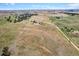 Wide aerial view of property surrounded by rolling grassland, scattered trees, a road and neighboring properties at 40121 County Road 21, Elizabeth, CO 80107