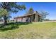 Grassy backyard view showcases the house with mature trees at 40121 County Road 21, Elizabeth, CO 80107