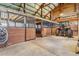 Spacious barn interior with wooden stalls, concrete floor and tractor, perfect for equine or agricultural use at 40121 County Road 21, Elizabeth, CO 80107