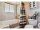 Bright bathroom featuring a tub with shower, tiled walls, and a decorative shower curtain at 40121 County Road 21, Elizabeth, CO 80107