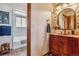 Elegant bathroom featuring a custom vanity with a vessel sink and a tub with tiled walls at 40121 County Road 21, Elizabeth, CO 80107