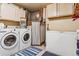 Well-equipped laundry room featuring a washer, dryer, freezer, and storage cabinets at 40121 County Road 21, Elizabeth, CO 80107