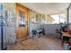A cozy enclosed brick porch with a patterned tile floor, a wooden door and large windows at 40121 County Road 21, Elizabeth, CO 80107