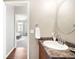 Bright bathroom with wood cabinets, granite countertop, towel rack, and mirror at 8571 Gold Peak Dr # F, Highlands Ranch, CO 80130
