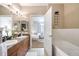 Bright bathroom with double sinks, wood cabinets, and access to the bedroom at 8571 Gold Peak Dr # F, Highlands Ranch, CO 80130