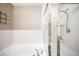 Bathroom featuring separate tub and shower with glass doors and tiled walls at 8571 Gold Peak Dr # F, Highlands Ranch, CO 80130