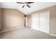 Bedroom with neutral carpet, tan walls, ceiling fan, and double door closet at 8571 Gold Peak Dr # F, Highlands Ranch, CO 80130