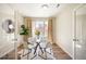 A breakfast nook featuring a glass table, four white chairs, a tree, and access to the backyard at 8571 Gold Peak Dr # F, Highlands Ranch, CO 80130