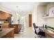 Modern kitchen featuring an island with seating, stainless steel appliances, and a desk area at 8571 Gold Peak Dr # F, Highlands Ranch, CO 80130