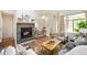 Elegant living room boasts a stone fireplace, wooden floors, and natural light at 8571 Gold Peak Dr # F, Highlands Ranch, CO 80130