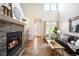 Cozy living room featuring a stone fireplace, wood floors, and ample natural light at 8571 Gold Peak Dr # F, Highlands Ranch, CO 80130