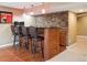 Bar area featuring a stacked stone accent wall, modern lighting, and comfortable seating, perfect for entertaining guests at 8766 Cresthill Ln, Highlands Ranch, CO 80130
