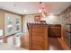 Basement bar area with wood cabinets, sink, microwave, mini fridge, stone accent wall and access to the backyard at 8766 Cresthill Ln, Highlands Ranch, CO 80130