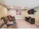 Cozy basement featuring a large, comfortable reclining sofa, entertainment center, and carpeted floors at 8766 Cresthill Ln, Highlands Ranch, CO 80130