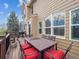 Deck with dining table, chairs with red cushions and wood railing that overlooks the yard and grill at 8766 Cresthill Ln, Highlands Ranch, CO 80130