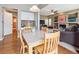 Dining area with hardwood floors, a granite table, wooden chairs, and a view into the living room with a fireplace at 8766 Cresthill Ln, Highlands Ranch, CO 80130