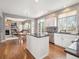 Bright kitchen with white cabinets, dark countertops, hardwood floors, an island, and stainless steel appliances at 8766 Cresthill Ln, Highlands Ranch, CO 80130