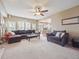 Inviting living room with large windows, a ceiling fan, ample seating, and an open layout to the kitchen at 8766 Cresthill Ln, Highlands Ranch, CO 80130