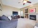 Comfortable living room with a fireplace, TV, ceiling fan, large windows, and plush seating at 8766 Cresthill Ln, Highlands Ranch, CO 80130