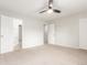 Bright bedroom with neutral carpet, ceiling fan, and ensuite bath entrance at 3667 W Union Ave # 2E, Denver, CO 80236