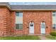 Charming brick townhome featuring two front doors and well-maintained landscaping at 3667 W Union Ave # 2E, Denver, CO 80236