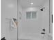 Clean and bright bathroom featuring a white tub with shower, and tiled walls at 7126 Joan St, Denver, CO 80221
