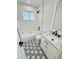 Modern bathroom featuring black and white patterned floor, sleek fixtures, and subway tiled walls at 7126 Joan St, Denver, CO 80221