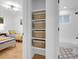 Bright bedroom with two twin beds, closet, and an attached bathroom featuring stylish storage baskets at 7126 Joan St, Denver, CO 80221