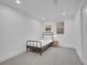 A cozy bedroom featuring a simple bed frame, a lamp, and a window with blinds at 7126 Joan St, Denver, CO 80221