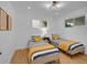 Cozy bedroom with two twin beds, sunny windows, and modern lighting fixtures, perfect for relaxation at 7126 Joan St, Denver, CO 80221