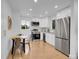Modern kitchen with stainless steel appliances, white cabinets, and a dining table at 7126 Joan St, Denver, CO 80221